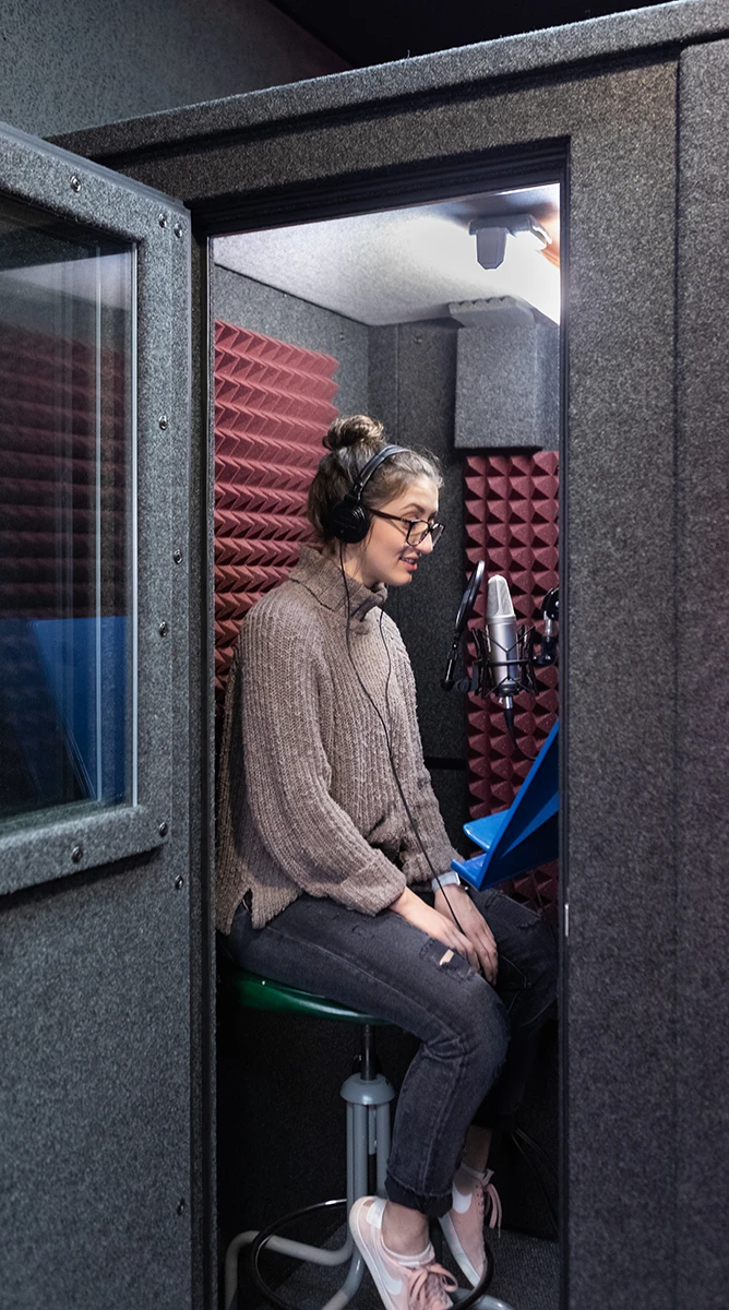 Voice artist in the sound isolated voice booth recording for an episode