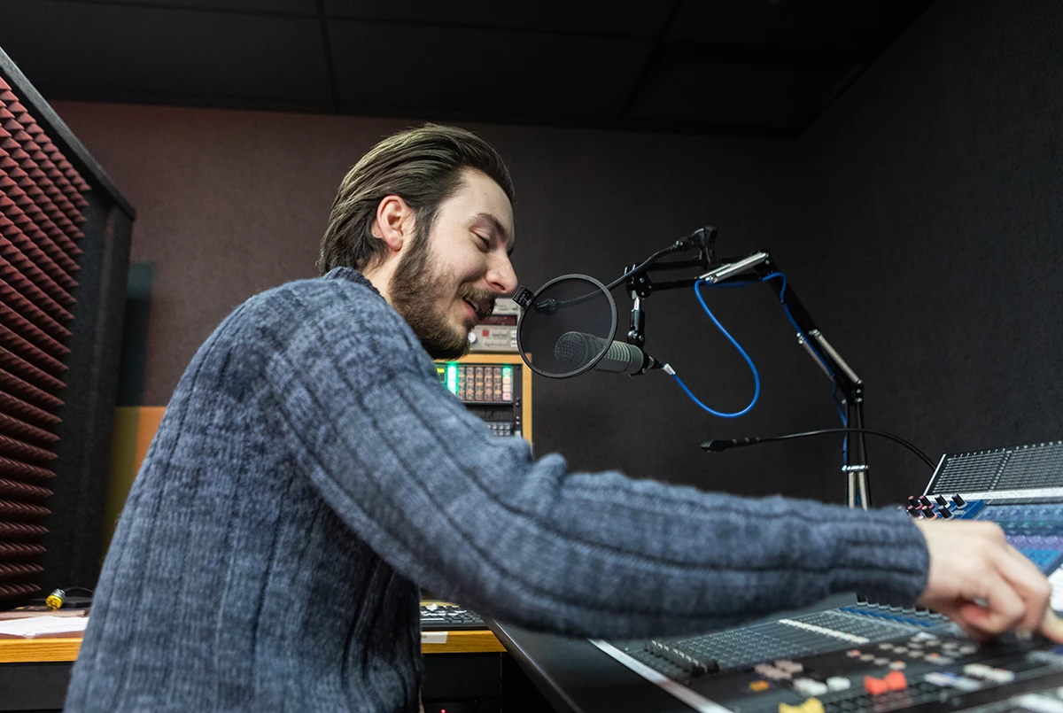 Man operating sound board to record a voice actor